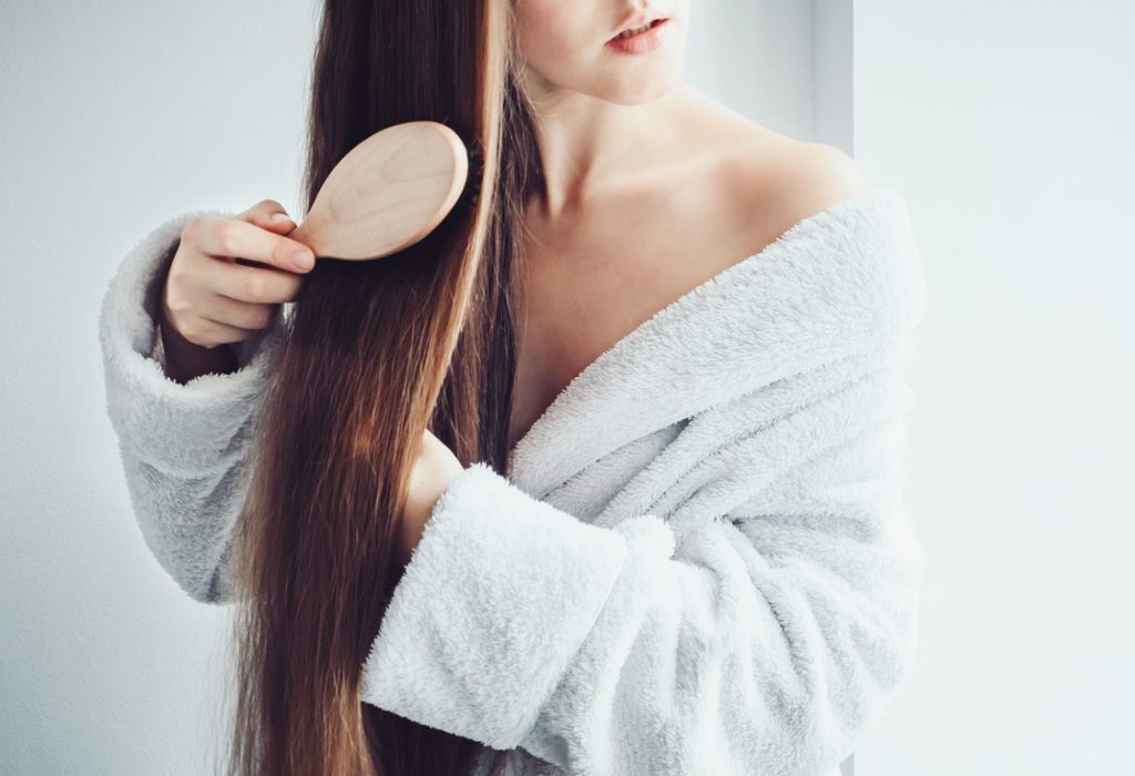 vrouw kamt haar na gebruik van toppik haarpoeder