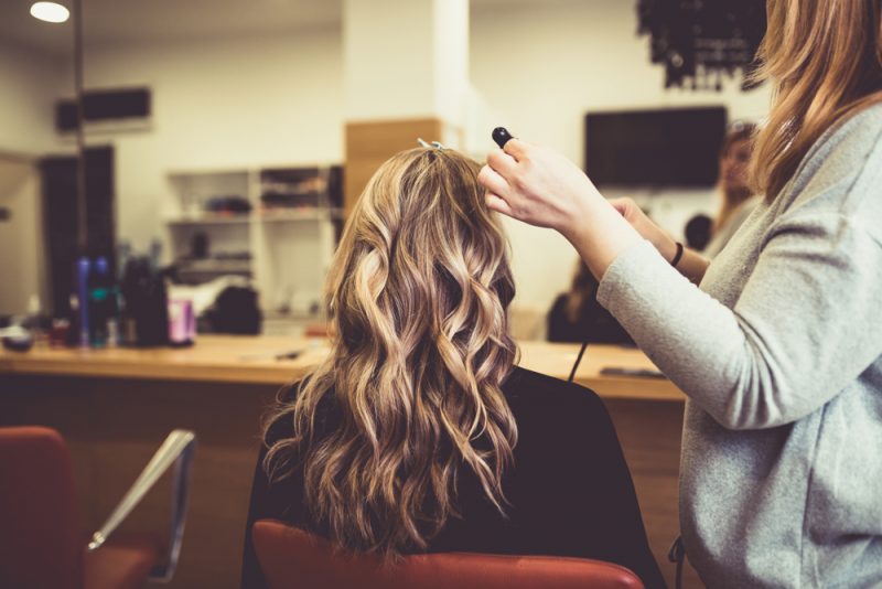 vrouw bij de kapper die Toppik Root Touch Up wilt proberen