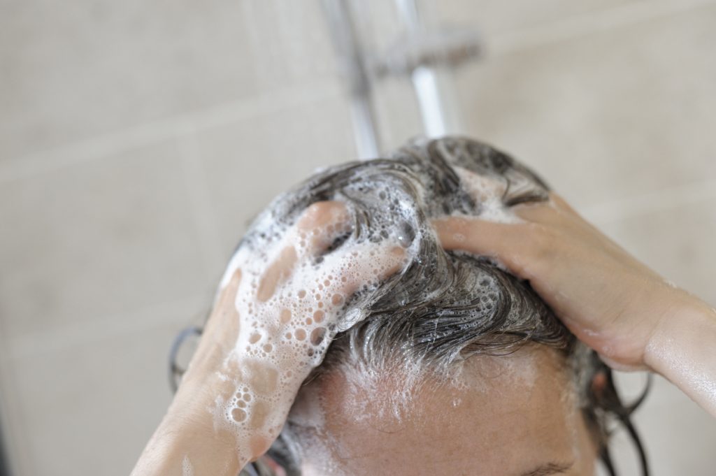 haar wassen met cafeïne shampoo onder de douche